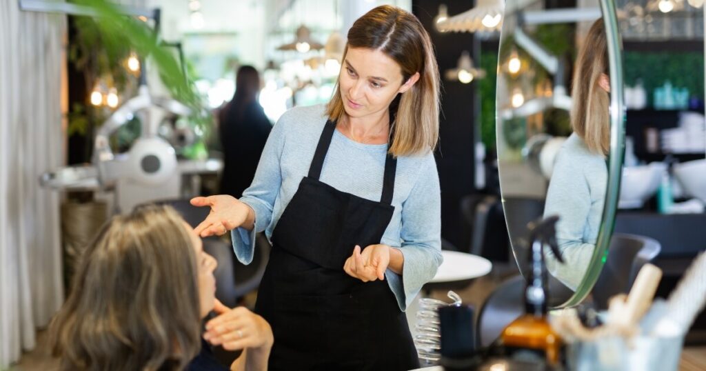 female-hairstylist-reviewing-options-with-older-client-1200-630 hair stylist having consultation with older client with gray hair