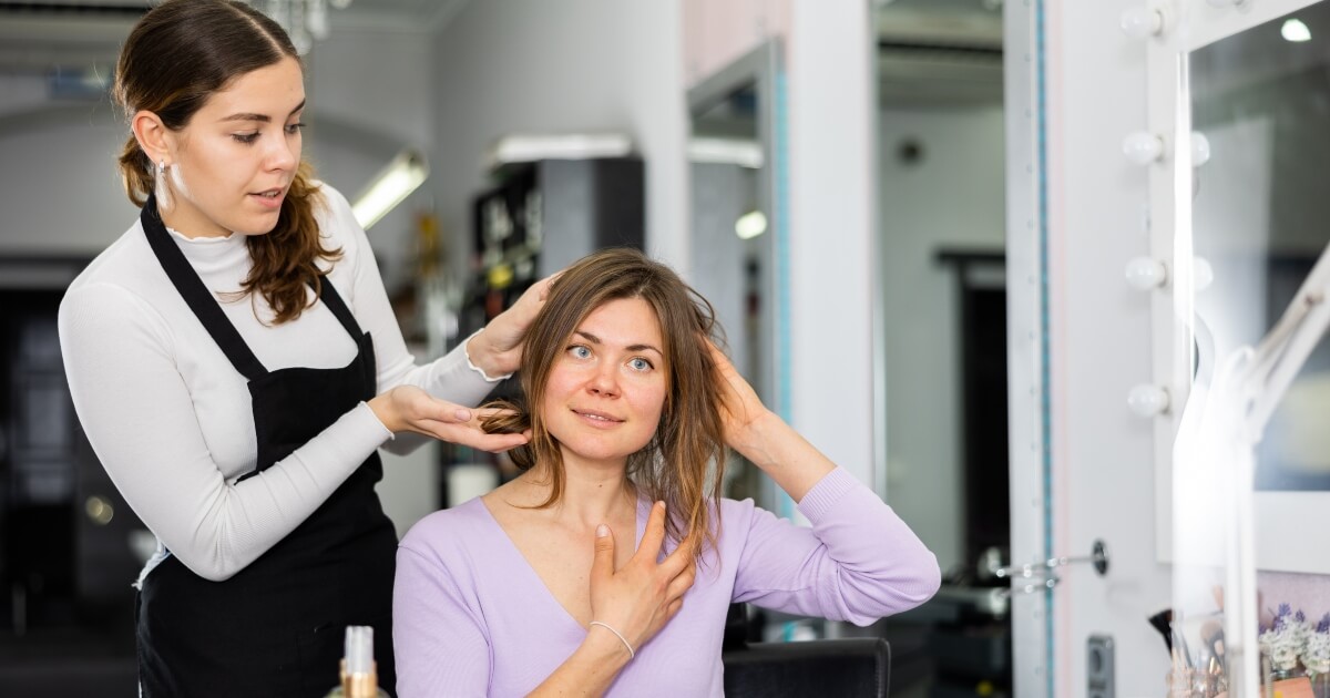 hairdresser discussing shorter hair styles with female client
