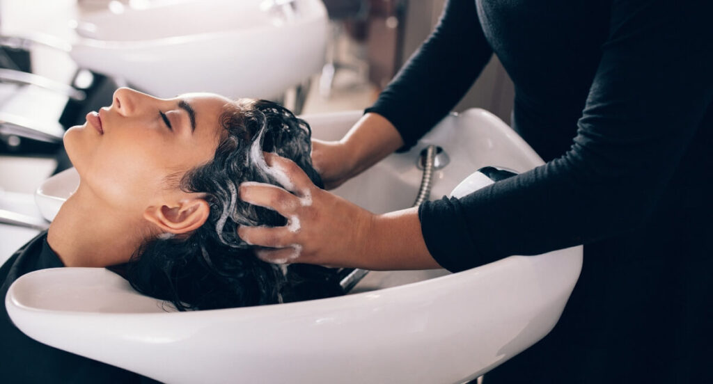 stylist-washing-hair-in-salon getting hair washed in a salon