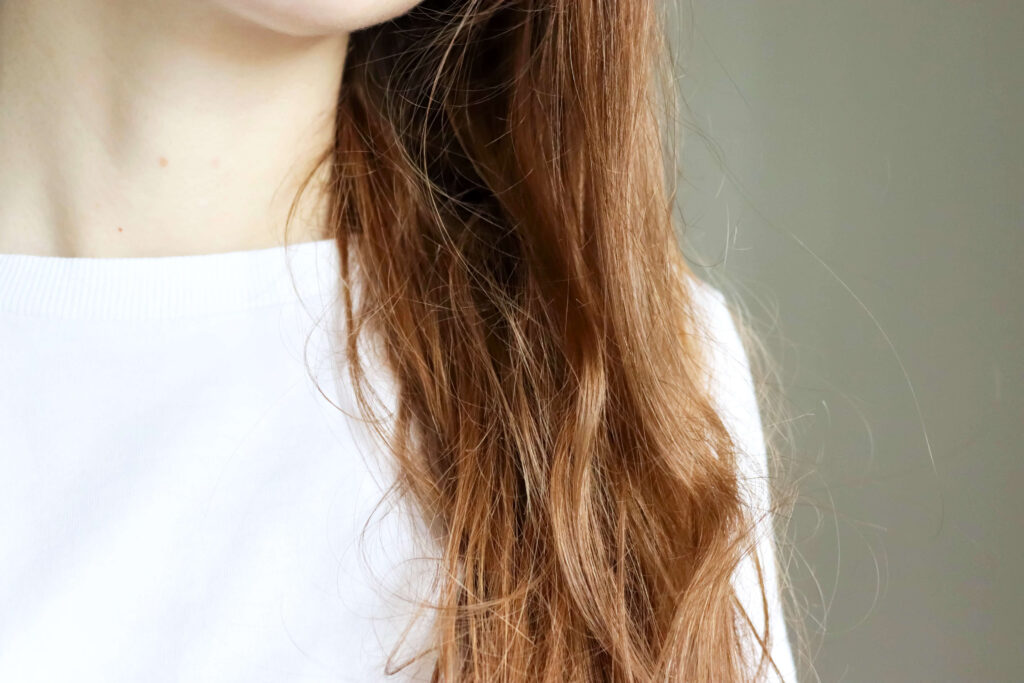 damaged brunette hair hanging in front of shoulder