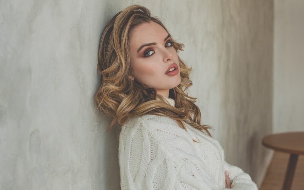 smiling winter complexion with plump lips wearing white sweater