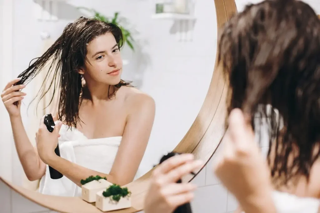 woman-spraying-product-in-hair-after-shower woman spraying product into wet hair after shower