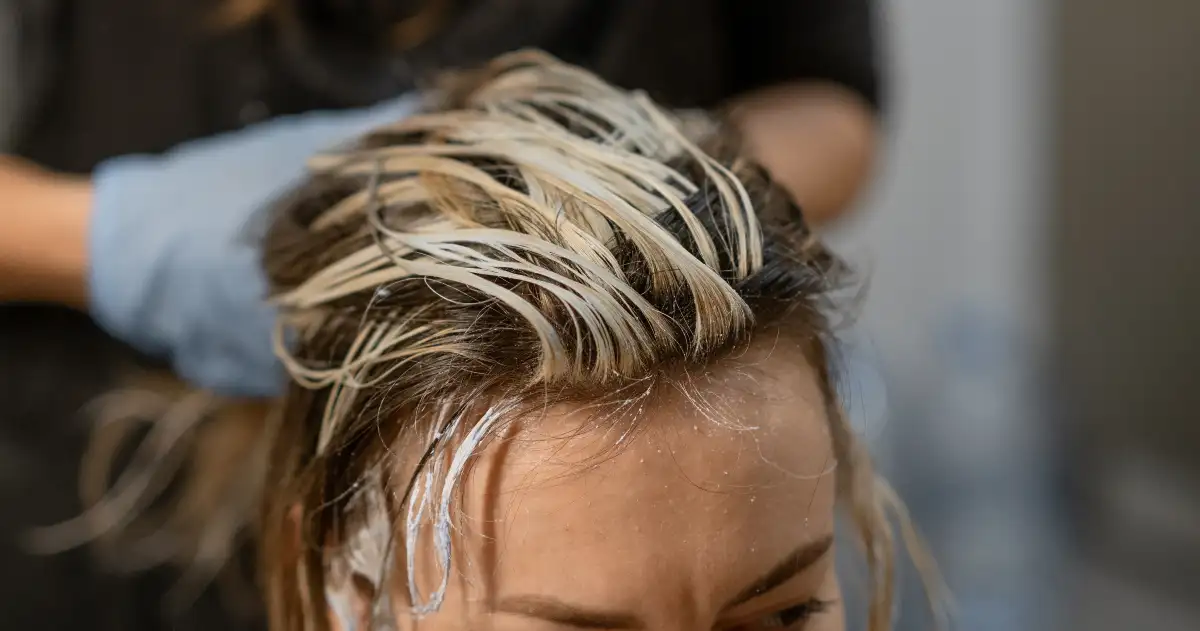 woman getting blond highlights on top of head